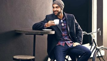 Shot of a handsome young man enjoying a cup of coffee at a cafe in the city while his bike stands next to him.