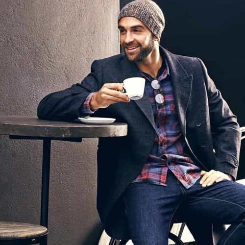 Shot of a handsome young man enjoying a cup of coffee at a cafe in the city while his bike stands next to him.